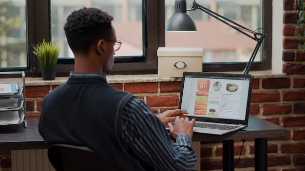 A US entrepreneur using project management software on a laptop, with charts and graphs showing efficient task management and progress tracking.
