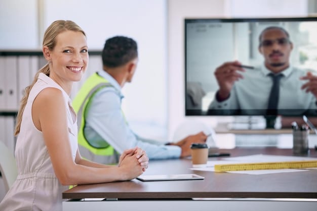 A young HR manager is conducting a video interview with a candidate. Both are smiling and the background shows a modern office space suggesting remote onboarding process.